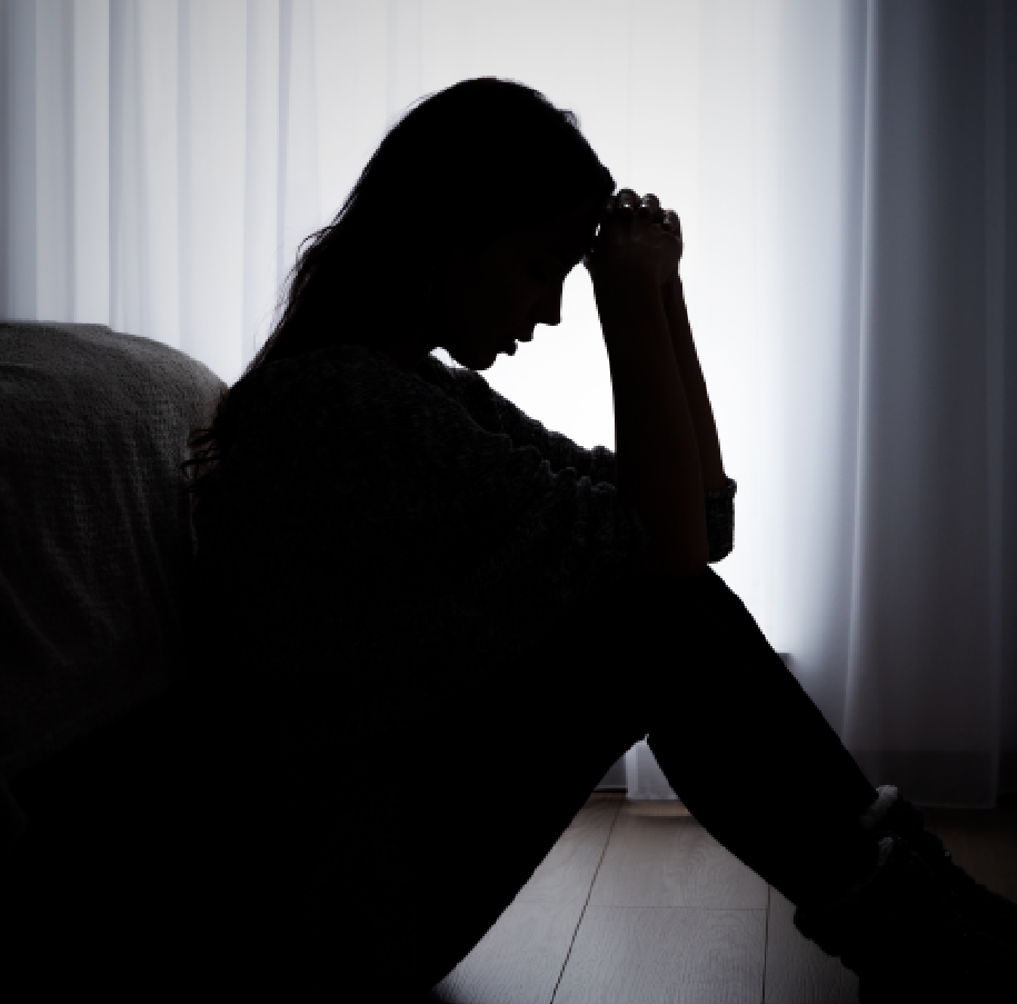 Silhouette of a woman sitting by a window.