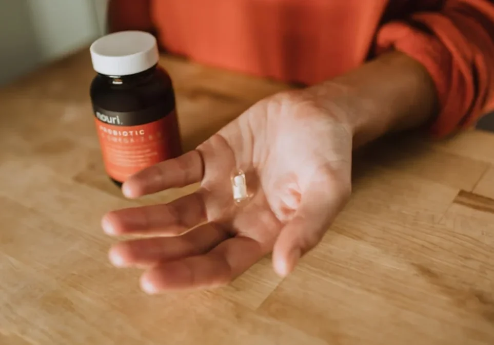 Hand holding a probiotic capsule.